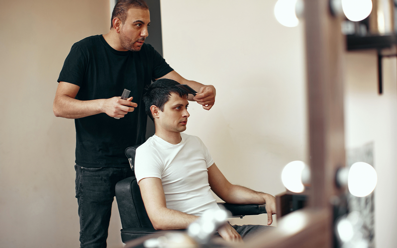 A stock photo of a man getting a haircut/with a barber.