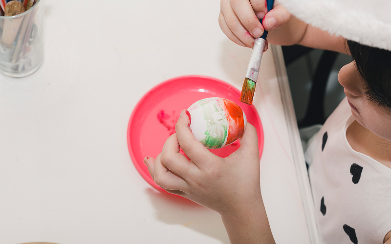 A child painting or sculpting with focus and joy, highlighting hands-on creative learning