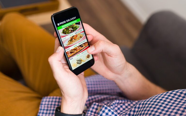 The 5 Best Platforms for Discovering Healthy Breakfast Delivery in Singapore a person using a smartphone for food delivery